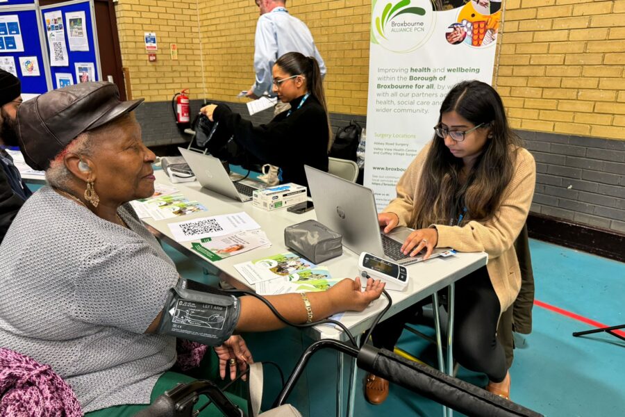 A patient sitting down has their blood pressure taken by a member of the Broxbourne Alliance Primary Care Network team during the volunteer fair.