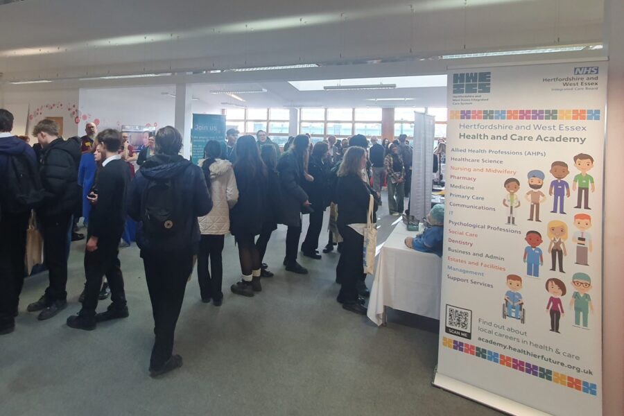 A large group of students gathered in a big, open room showcasing careers in health and social care.