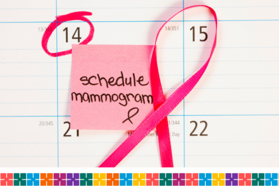 A wall calendar with a pink post-it note saying 'schedule mammogram', a pink ribbon and a pink circle drawn around a date.