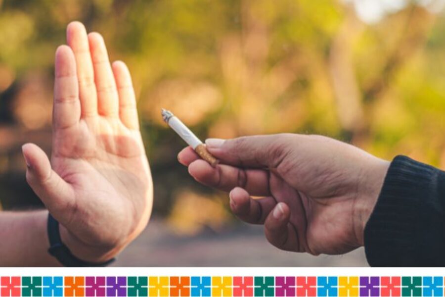 A hand held up as if to say 'stop' while another hand belonging to a different person offers them a cigarette.