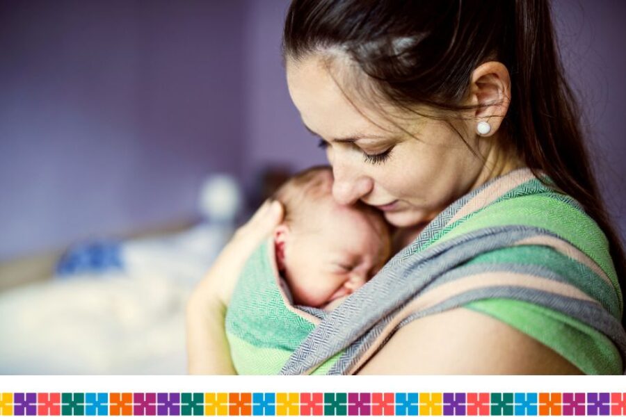 Woman with newborn baby in sling