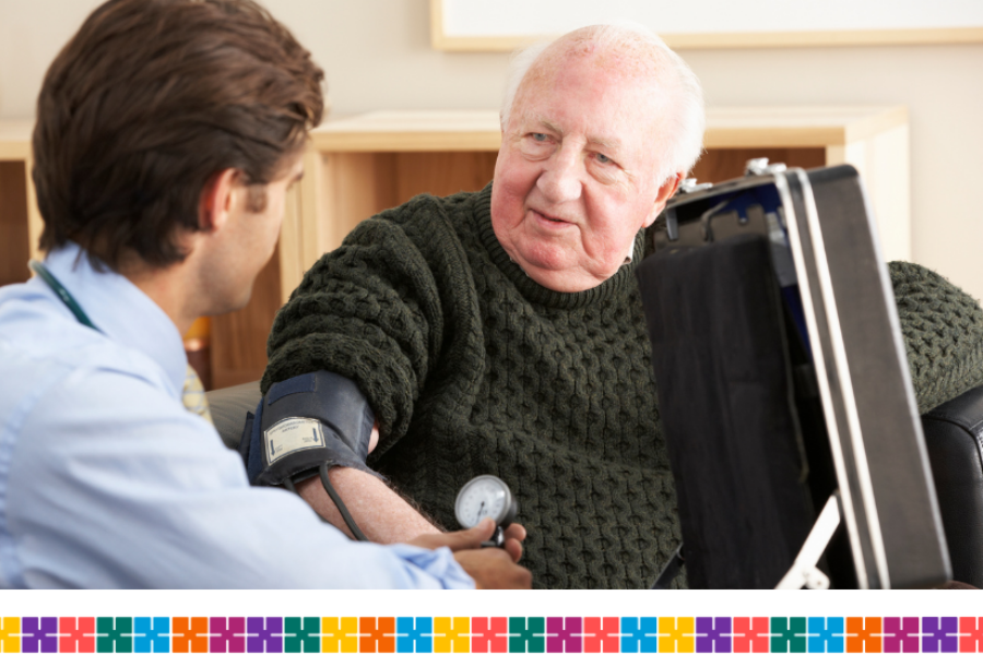 Elderly male patient having his blood pressure taken by a GP.